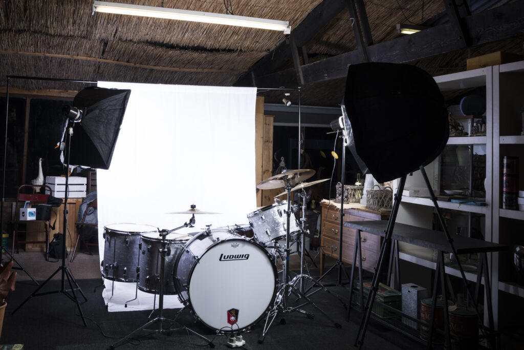 A photography studio set up, in front of a drum kit.